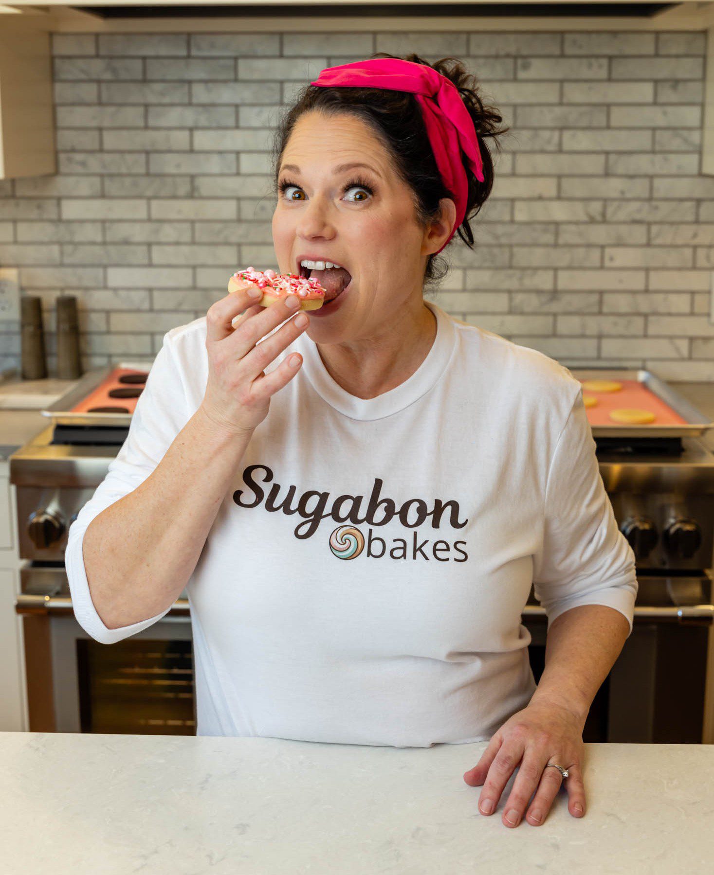 Woman enjoying sprinkled donut in kitchen